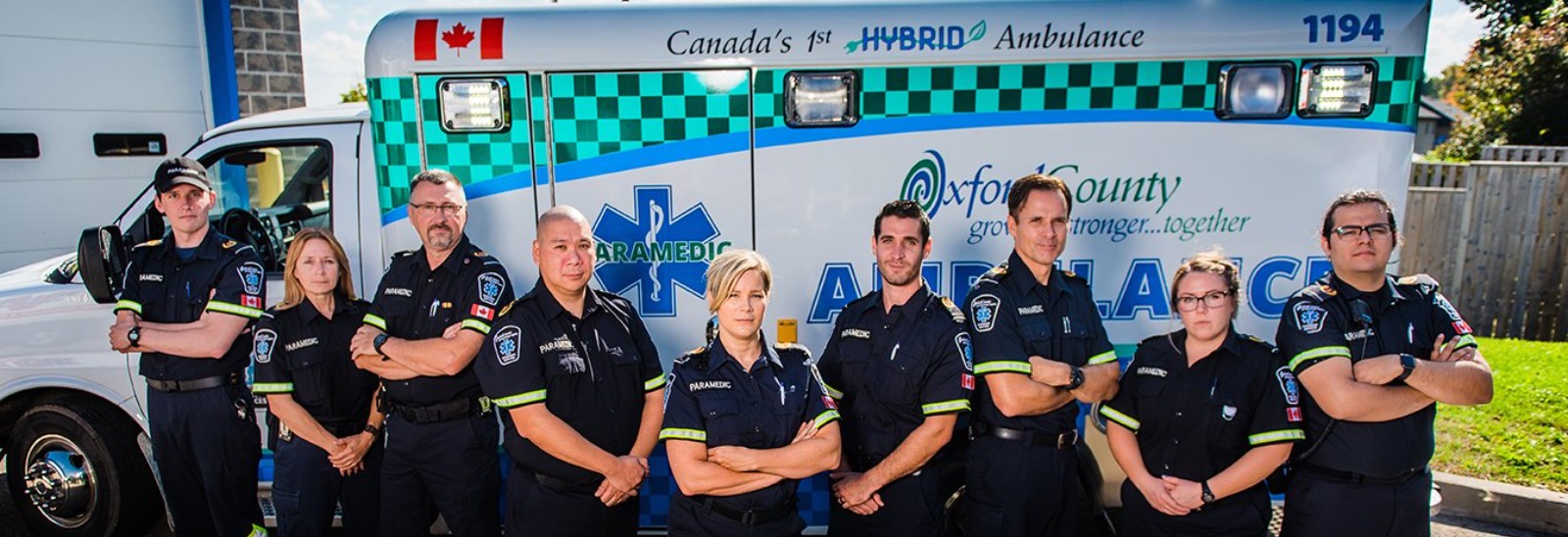 row of paramedic people posing in front of an ambulance