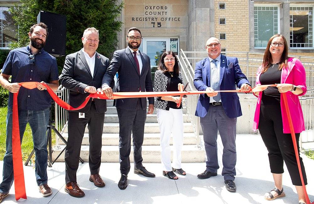 Ribbon cutting for Oxford EarlyON building with local dignitaries holding a ribbon